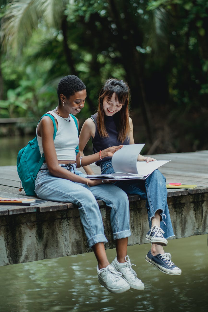 diverse women turning pages of copybook